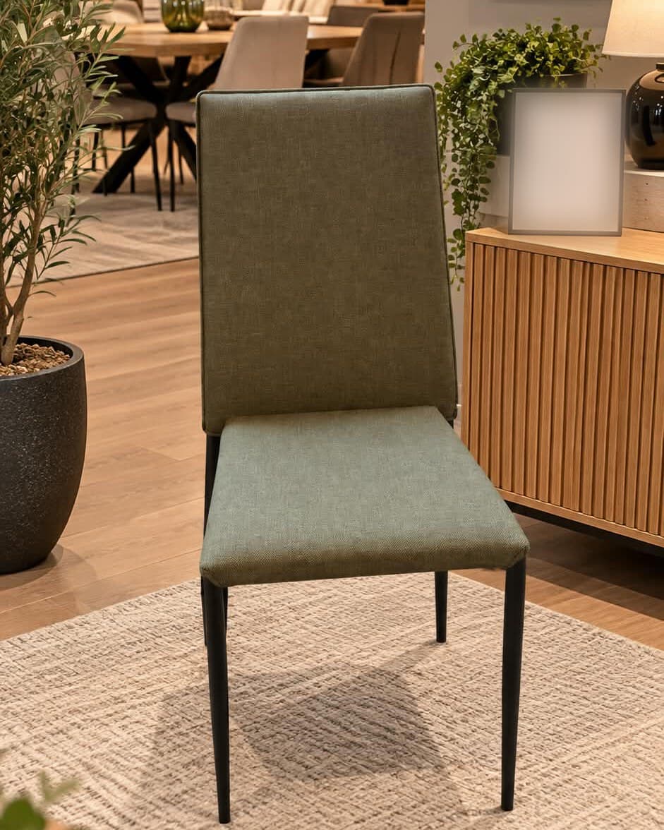 Chaise moderne à dossier haut et assise garnis de tissu vert sauge, passepoil sur le contour du dossier, quatre pieds fuselés en métal noir